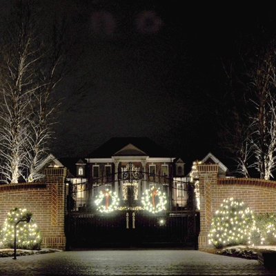 This home entrance has beautiful holiday curb appeal with wreaths and garland on the gate. Photo